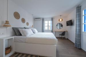 a white bedroom with a white bed and a window at Luxury Apartment En Lefko in Poros