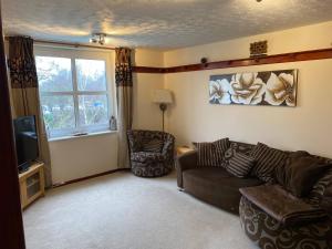 a living room with a couch and a television at River Penthouse Apartment In The Heart of in Saint Neots