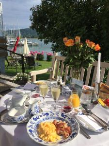 una mesa con un plato de comida para el desayuno. en Hotel Sommerhaus Garni am See, en Bodman-Ludwigshafen