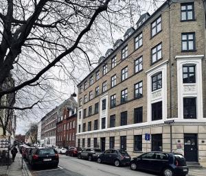 a city street with cars parked in front of a building at ApartmentInCopenhagen Apartment 1389 in Copenhagen