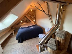 a attic bedroom with a bed in the attic at Vakantiewoning met sauna & hottub en zwempoel op Natuurterrein in Heuvelland