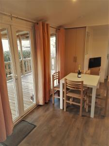 een eetkamer met een tafel en een balkon bij MOBIL HOME Tendance Tout Confort - FUNPASS non included in Gastes