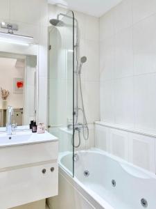 ein weißes Badezimmer mit einer Badewanne und einem Waschbecken in der Unterkunft Vintage Top Centre Apartment in Sofia