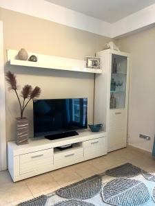 a large white entertainment center with a flat screen tv at Los Jardines Isla Canela in Huelva