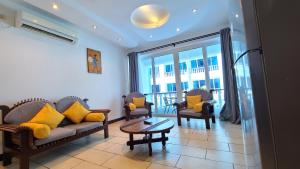 un soggiorno con divano, 2 sedie e tavolo di c3 Cowrie Shell Residences a Mombasa