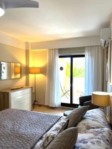 a bedroom with a bed and a view of a patio at Los Jardines Isla Canela in Huelva
