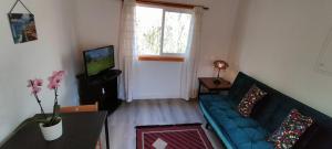 ein Wohnzimmer mit einem blauen Sofa und einem TV in der Unterkunft Sintra Serenity in Sintra