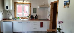 eine Küche mit weißen Schränken, einem Waschbecken und einem Fenster in der Unterkunft Sintra Serenity in Sintra