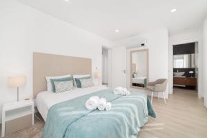 a bedroom with a bed with two towels on it at Villa Atlântico - By SCH in Salir do Porto +25 photos