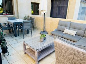 a patio with a couch and a table and chairs at Los Jardines Isla Canela in Huelva