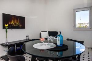 a dining room table with a bottle and glasses on it at Apartments Zdeslav in Rogoznica