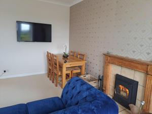 a living room with a couch and a fireplace at Bogrie Cottage in Canonbie