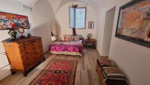 a bedroom with a bed and a dresser and a rug at Beautifully restored romantic apartment in the centre of historic Dolcedo in Dolcedo