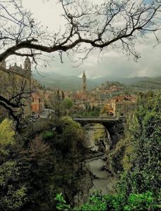 a bridge over a river with a city in the background at Beautifully restored romantic apartment in the centre of historic Dolcedo in Dolcedo