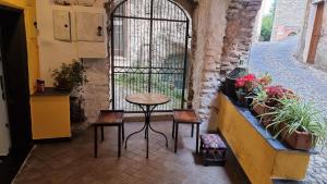 patio con mesa, sillas y ventana en Beautifully restored romantic apartment in the centre of historic Dolcedo, en Dolcedo