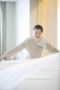 a young boy is smiling while leaning on a bed at The Longemont Shanghai in Shanghai