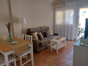 - un salon avec un canapé et une table dans l'établissement Aldea Playa Golf 2 dormitorios, à Huelva