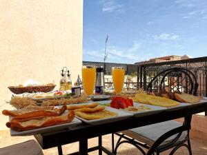uma mesa coberta com pratos de alimentos e bebidas em Riad Bijoux em Marraquexe