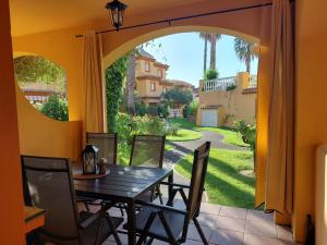 comedor con mesa y vistas a un patio en Aldea Playa Golf 2 dormitorios, en Huelva