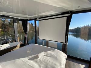 a bed on a boat with a view of a lake at Escale Royale Saint Fargeau in Boissise-le-Roi