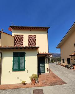 una casa con persianas verdes y entrada en L'Appartamentino, en Lucca