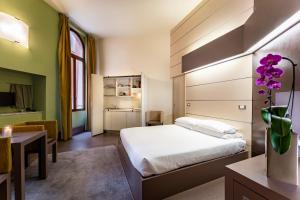 a hotel room with a bed and a desk and a room at Residenza Manin Apartments in Venice