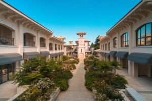 a walkway through a building with flowers and a clock tower at Primorski Hotel in St. St. Constantine and Helena