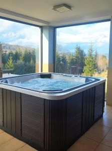 a large hot tub in a room with a large window at Willa Pod Janowcem in Stronie Śląskie