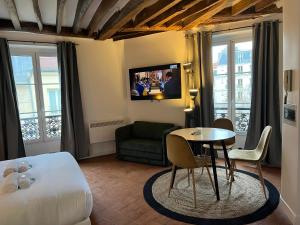 a hotel room with a bed and a table and a couch at Conde Chic Studio in Paris