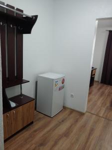 a room with a white refrigerator and a wooden floor at КП ДР Готель in Drogobych +23 photos
