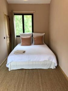 1 dormitorio con 1 cama blanca grande y ventana en Cévennes - Superbe chambre d'hôtes moderne et indépendante, en Monoblet