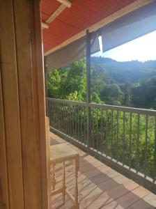 une terrasse couverte avec une chaise et une vue sur les montagnes dans l'établissement Hostal y cabañas los Juanes, à Jardín