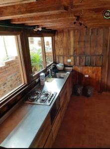 ハルディンにあるHostal y cabañas los Juanesのキッチン(コンロ、シンク付)、窓2つが備わります。