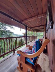 eine Veranda mit einem Sofa und Stühlen auf einer Terrasse in der Unterkunft Hostal y cabañas los Juanes in Jardin