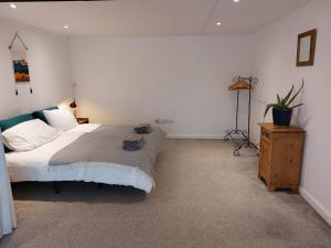 1 dormitorio con 1 cama grande y vestidor de madera en Beech House 20 minute walk to Airport, en Bristol