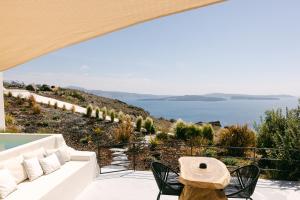 a woman sitting on a balcony looking out at the ocean at Le Cote Oia in Oia