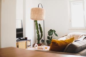 ein Wohnzimmer mit einem Sofa und einem Kaktus in der Unterkunft Ocean View Ha Apartment in Cádiz