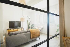 ein Wohnzimmer mit einem Sofa und einem TV in der Unterkunft Ocean View Ha Apartment in Cádiz