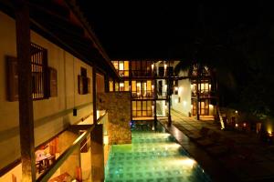 einen Innenhof eines Gebäudes mit Pool in der Nacht in der Unterkunft Elephant Trail in Udawalawe