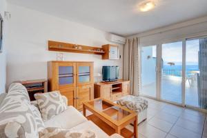 a living room with a couch and a tv at Los Gigantes Sea View in Santiago del Teide