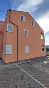 an orange building with white windows on the side of it at Apartments Mediterranean Sundance in Vodice