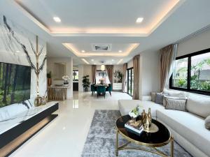 uma sala de estar com um sofá branco e uma mesa em Southern Peak Pool Villa Huay Yai Pattaya em Ban Huai Yai