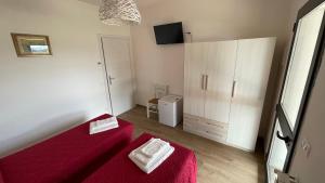 ein kleines Zimmer mit einem roten Bett und einem Schrank in der Unterkunft Agriturismo Da Pietro in Pomarance
