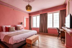 a bedroom with pink walls and a bed and a desk at Boutique hotel Sies in Watervliet