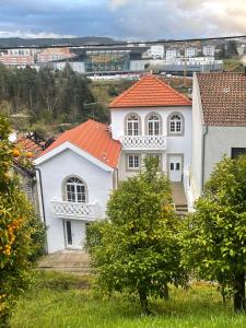 een wit huis met een oranje dak bij Prado 20 Twin in Vila Real