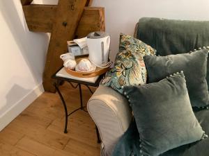 a table with a coffee maker on top of a couch at Chambres d'hôtes Le Relais de la Perle in Le Vernois