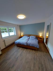 1 dormitorio con 1 cama y suelo de madera en a Bäckesch 17 en Nettersheim