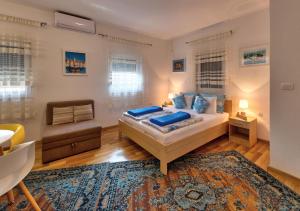 モスタルにあるVilla Acapulcoのベッドルーム1室(ベッド1台、椅子、ラグ付)