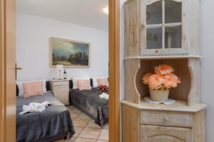 a room with a bed and a cabinet with flowers in it at Apartment with Veranda Toruńska Pobierowo by Renters in Pobierowo
