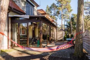 a hammock is tied to a house at Apartment with Veranda Toruńska Pobierowo by Renters in Pobierowo